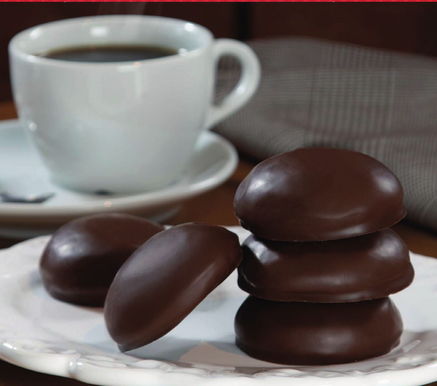 Beijinhos de mel com cobertura de chocolate ao lado de uma xícara de café